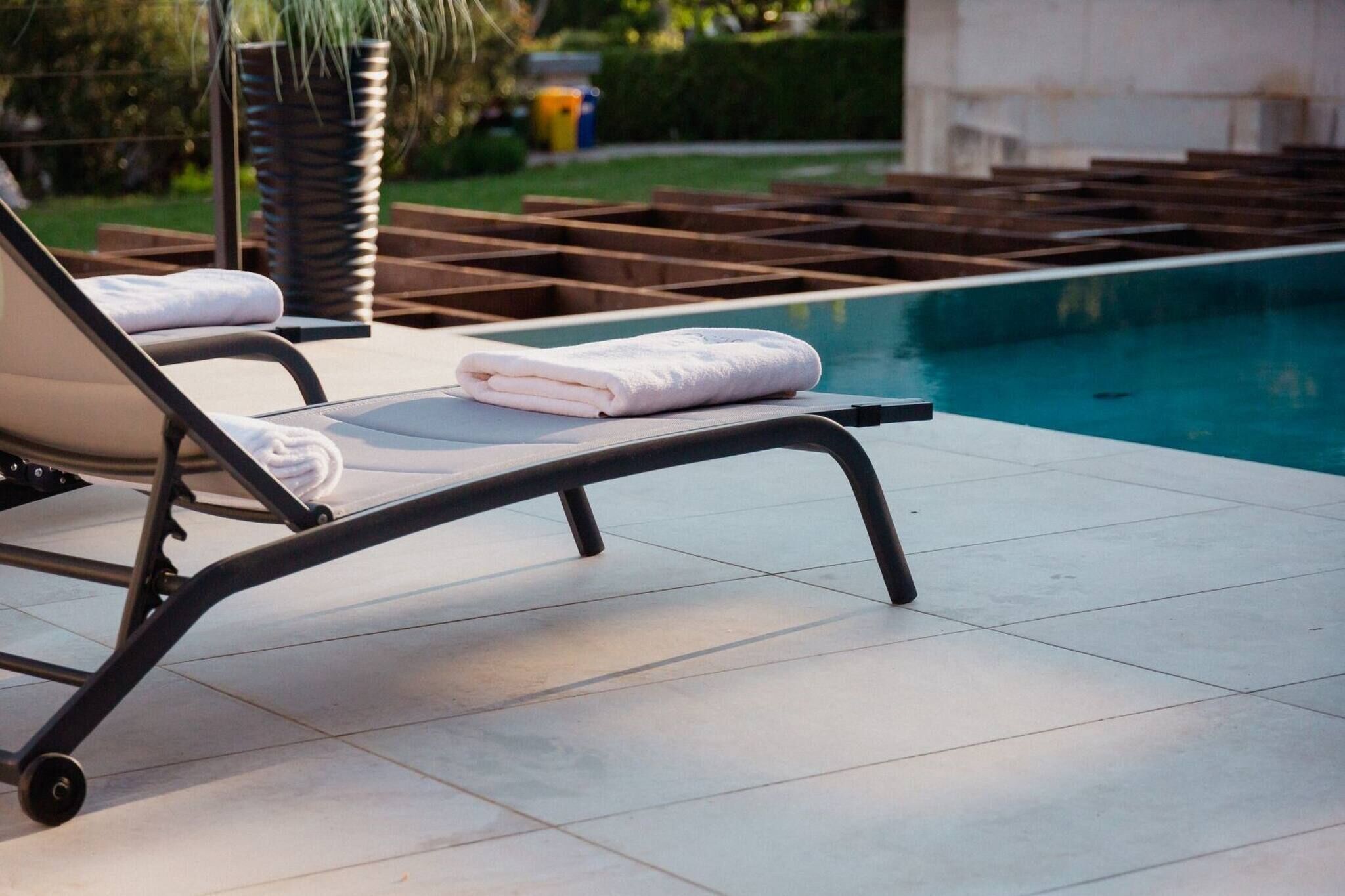 A poolside area with lounge chairs and a pool.