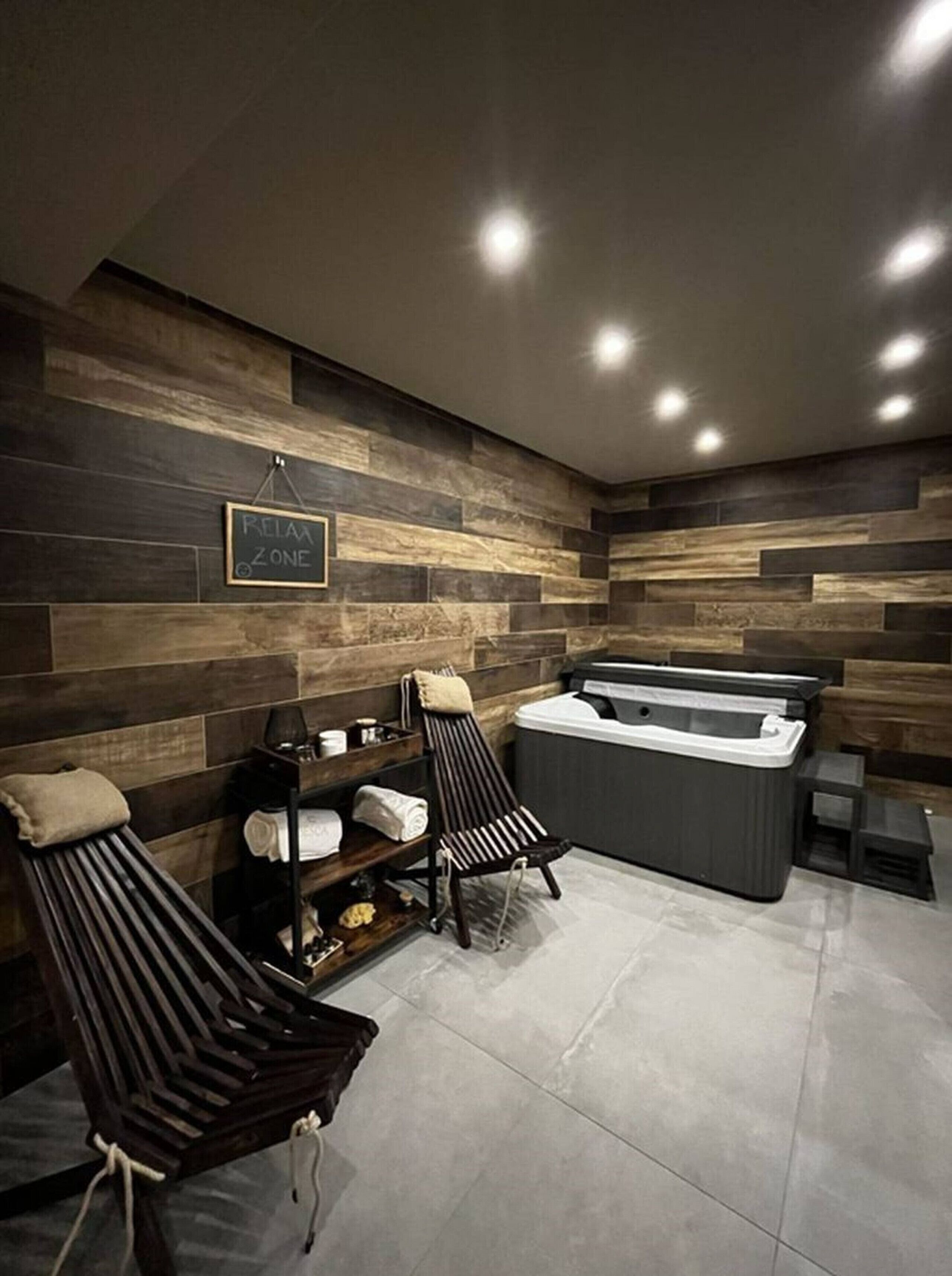 Ein Wellnessbereich mit Massagesesseln, einer Whirlwanne und einem Handtuchregal.