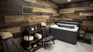 A spa area with a massage chair, another massage chair, a hot tub, and a shelf with towels. - Luxury Villa Krk Baska II with Heated Pool (Baska)