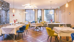 A restaurant with multiple tables, chairs, and hanging light fixtures. - Le Soleil D'or (Montigny-la-Resle)