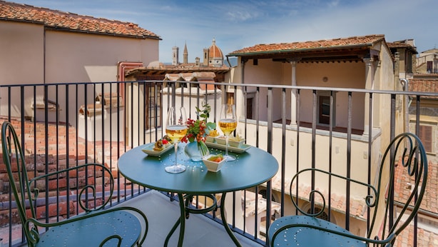 A balcony with a round table set for two, featuring a vase with flowers and two glasses of wine. - Visconte Filippo - La Dimora degli Affreschi Florence (Florence)