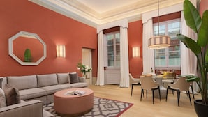 A modern living room with a sofa, round coffee table, and dining area with chairs. - Visconte Filippo - La Dimora degli Affreschi Florence (Florence)