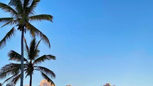 A waterfront area with palm trees, a dock with lounge chairs, and a small building with a white roof. - Luxury Waterfront Home on Harrington Sound in Smith's Parish (Flatts Village)