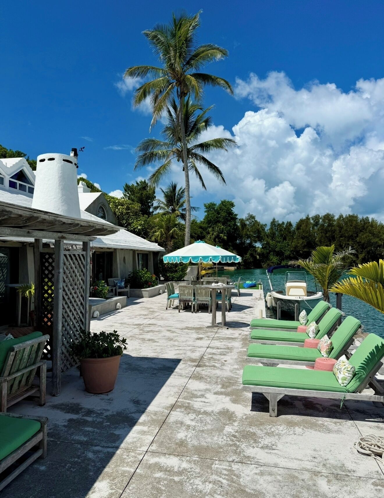 Un espace aménagé au bord de la piscine, avec des chaises longues, une table et un coin salon abrité.