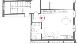 Planta baixa de um quarto de hotel com cozinha compacta, área de refeições, banheiro e sala de estar.