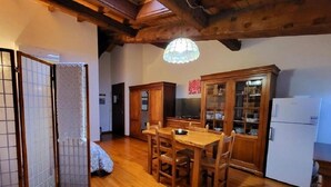 Uma cozinha japonesa tradicional com mobiliário de madeira, uma mesa de jantar e uma geladeira.