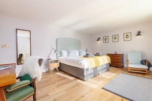 Ein Schlafzimmer mit Bett, Stuhl, Kommode, Schreibtisch und Spiegel.