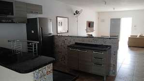 A kitchen with a refrigerator, microwave, and a tiled backsplash. - House with pool and huge backyard for children!!! (Peruíbe)