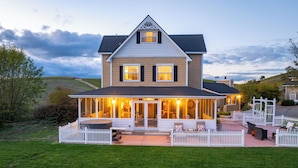 A two-story house with a covered patio, a fenced yard, and a view of the surrounding landscape. - Hot Tub + Fire Pit | Vineyard Near Templeton + Paso | Vineyard Retreat (Templeton)