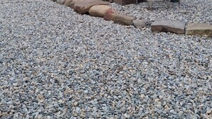 A rustic wooden shed with a slanted roof and large doors, situated on a gravel path surrounded by trees. - Redarrow rustic yurt  in the Adirondacks,  Gore Mt. 15 mins, jug water supplied (Minerva)