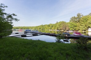 Lammelle ulottuva laituri, jossa on veneitä, ja taustalla näkyy talo.