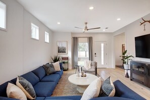 Ein Wohnzimmer mit blauem Sofa, Couchtisch und Fernseher.