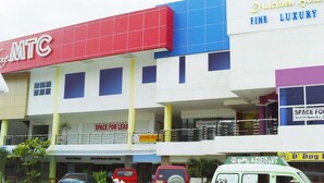 Un edificio de varios pisos con fachada roja y azul, un letrero que dice Outlines Hotel y un anuncio de local en alquiler.