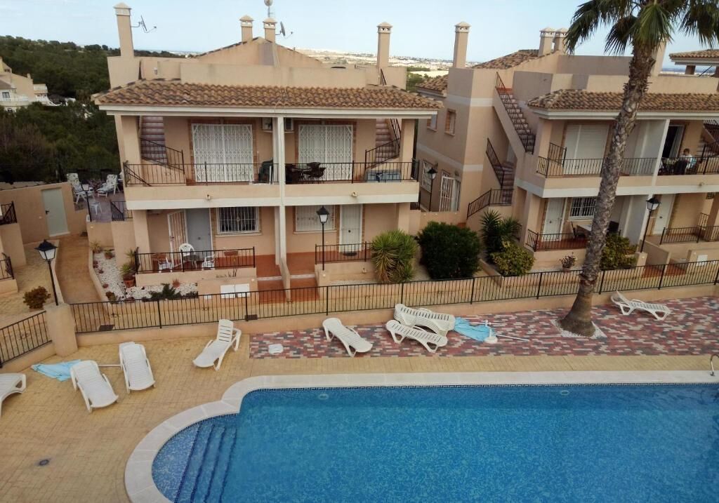 Um hotel de vários andares com piscina, varandas e áreas de estar ao ar livre.