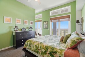 Une chambre à coucher avec un lit, une commode et un balcon offrant une vue.