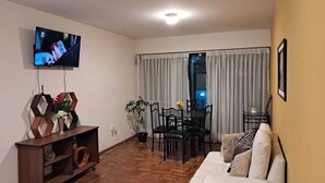 A living room with a sofa, TV, wooden cabinet, dining table, chairs, and a potted plant. - La Paz, Bolivia; Wonder City, Nice Apartment, Central and safe (La Paz)