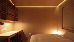 A bedroom with a bed, a desk, and built-in shelving. - Homegarden Park (Pyeongtaek)