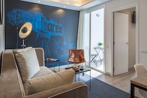 A modern living room with a large wall mural, a sofa, a coffee table, and a chair.