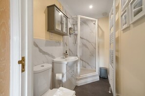 A bathroom with a toilet, sink, and shower.