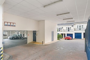 Een parkeergarage met een auto op de voorgrond en een andere op de achtergrond.