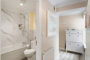 Bathtub, hair dryer, towels, shampoo