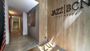 Un couloir avec un mur en bois sur lequel est affiché un panneau indiquant « JAZZ BCT Apartments ».