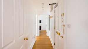 A hallway with white doors and wooden flooring. - Calm Leicester Sq 1BR (London)