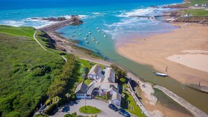 Une zone côtière comprenant une plage, des bateaux et un ensemble de bâtiments historiques.