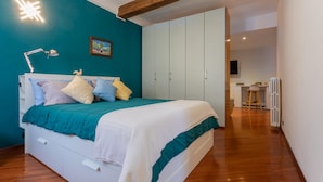 A bedroom with a bed, a desk, and a radiator. - Quartieri Central Home by Wonderful Italy (Turin)