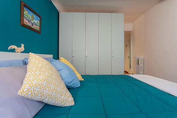 Une chambre à coucher avec un lit, une armoire et un radiateur.
