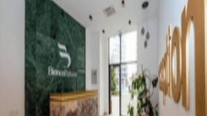 Een receptiehal met een marmeren vloer, een receptiebalie en een groene muur met het logo 'Benetton'.