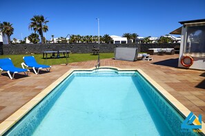 Relax by the serene pool, surrounded by a comfortable deck and lounge chairs.