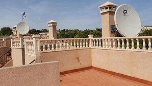 Terraço no telhado com antenas parabólicas, guarda-corpo e vista da região.