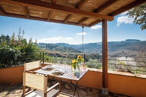 An outdoor dining area with a table set for two, overlooking a scenic valley. - Agriturismo Poggio Nardini (Montelupo Fiorentino)