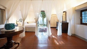Una habitación con una cama, una mesa con un adorno, una ventana y vistas al exterior.