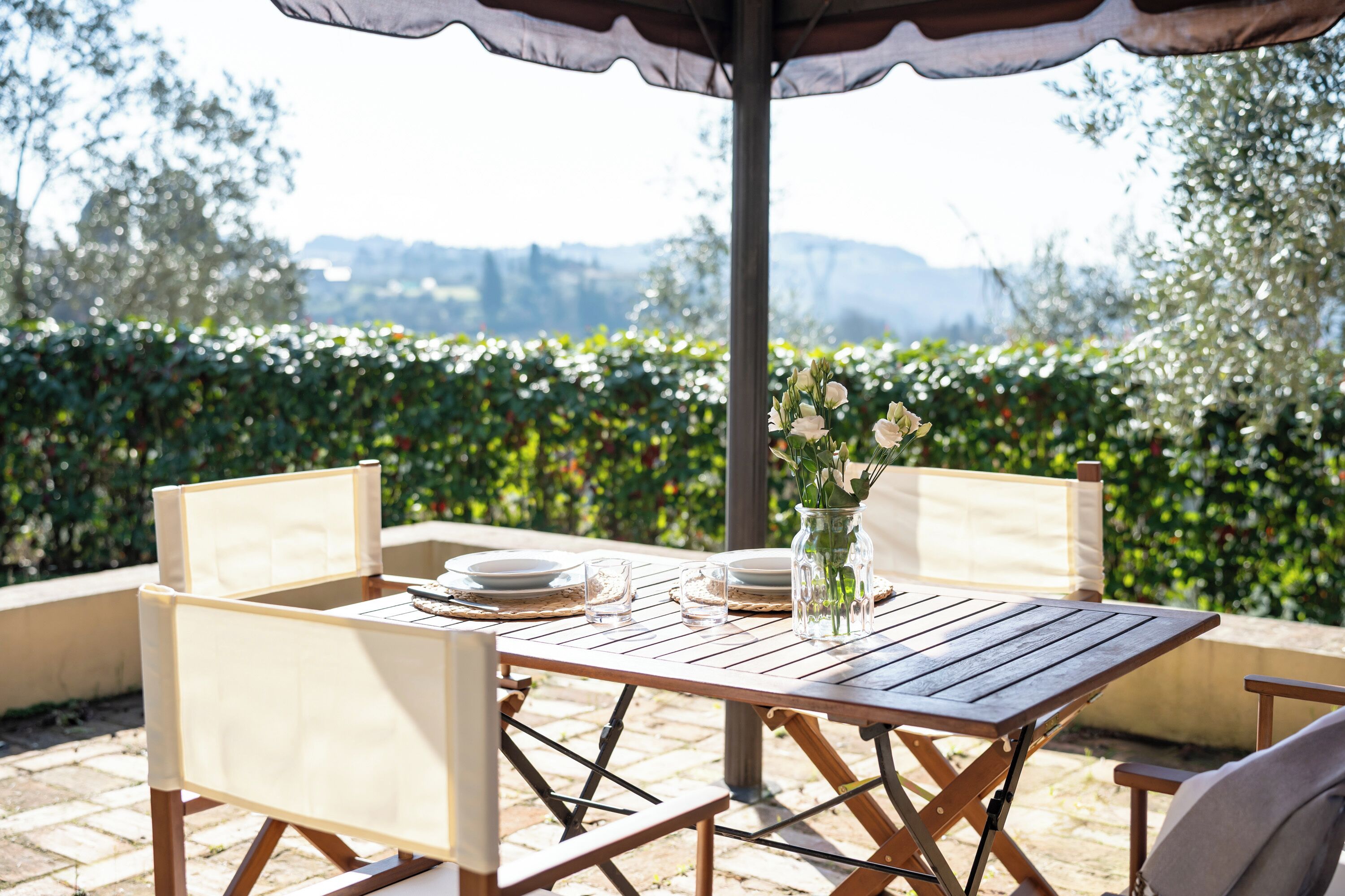 An outdoor dining area with a table, chairs, and a canopy.