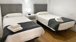 A hotel room with two single beds, a bedside table with a lamp, and a wooden floor. - Studio 1 bed 1 bath for 3  *No Terrace* F-3 (Marbella)