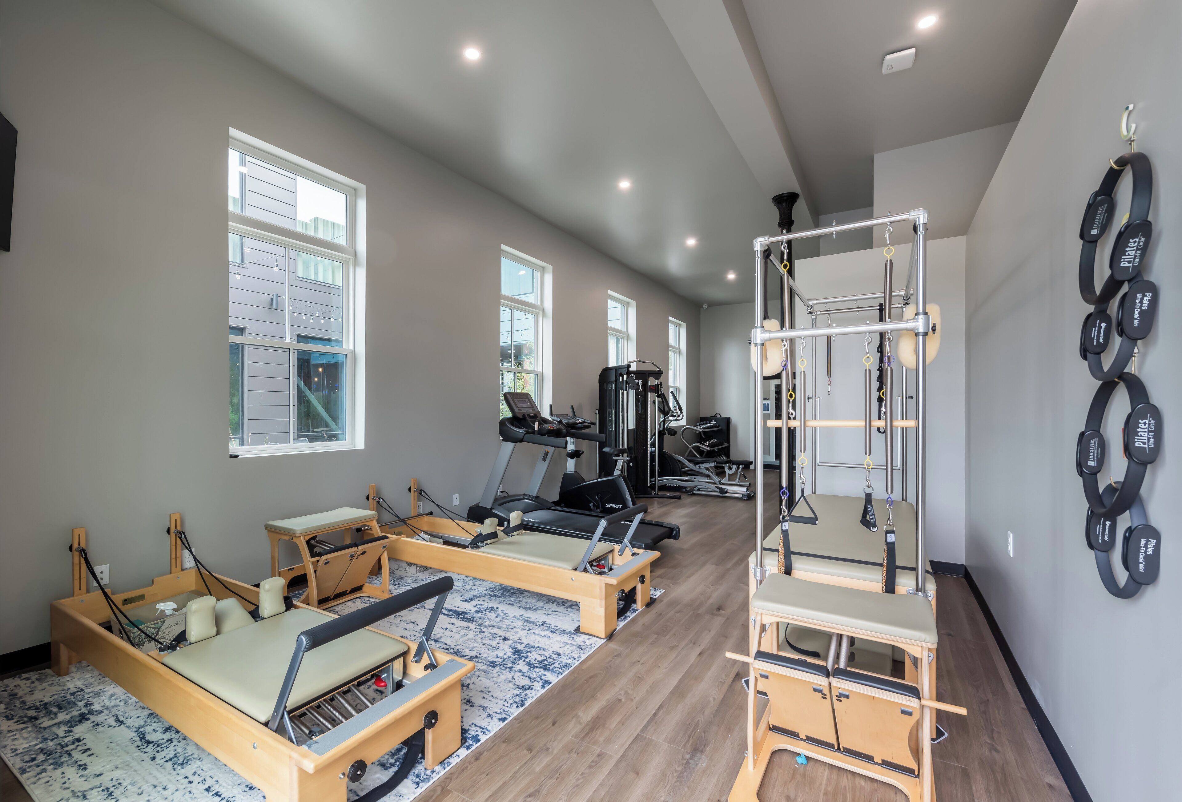 A gym with Pilates equipment, treadmills, and weight machines.
