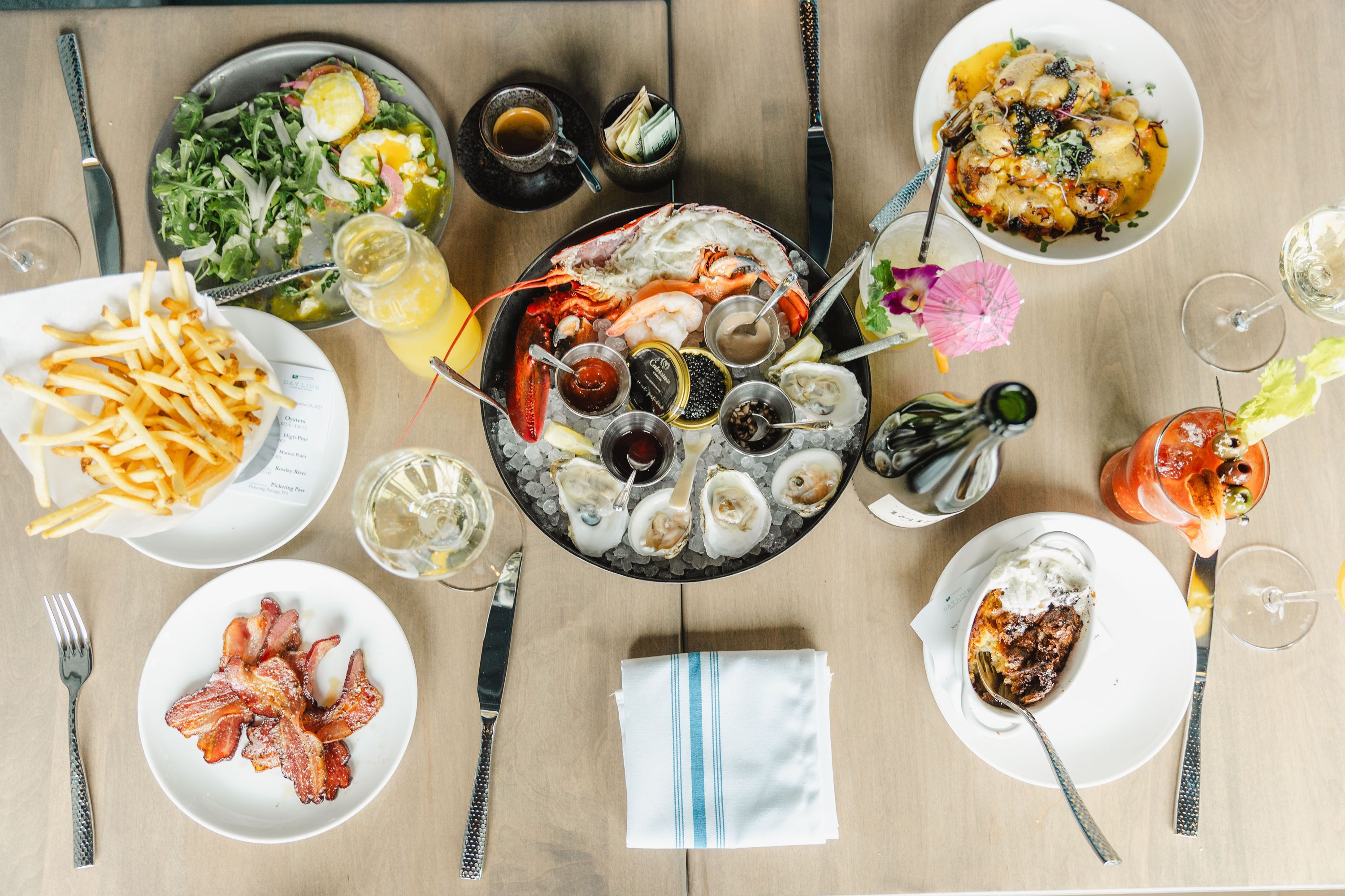 A dining table with various dishes, including seafood, salads, and a dessert.