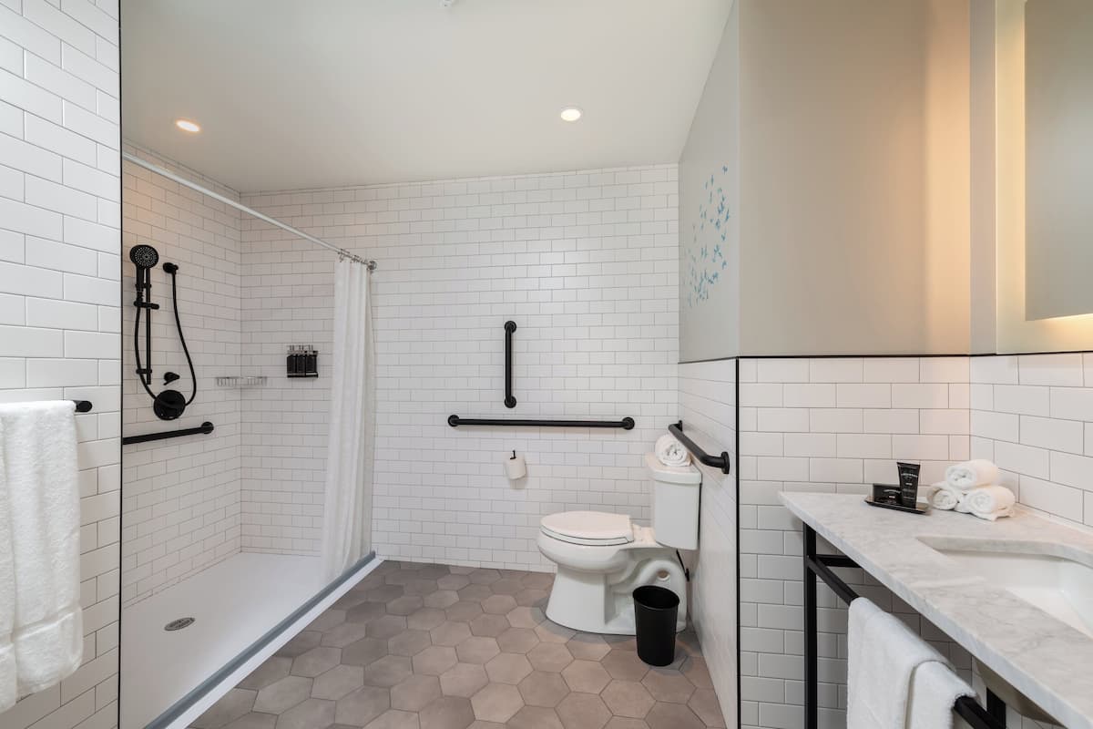 Een moderne badkamer met een douche, toilet en wastafel.