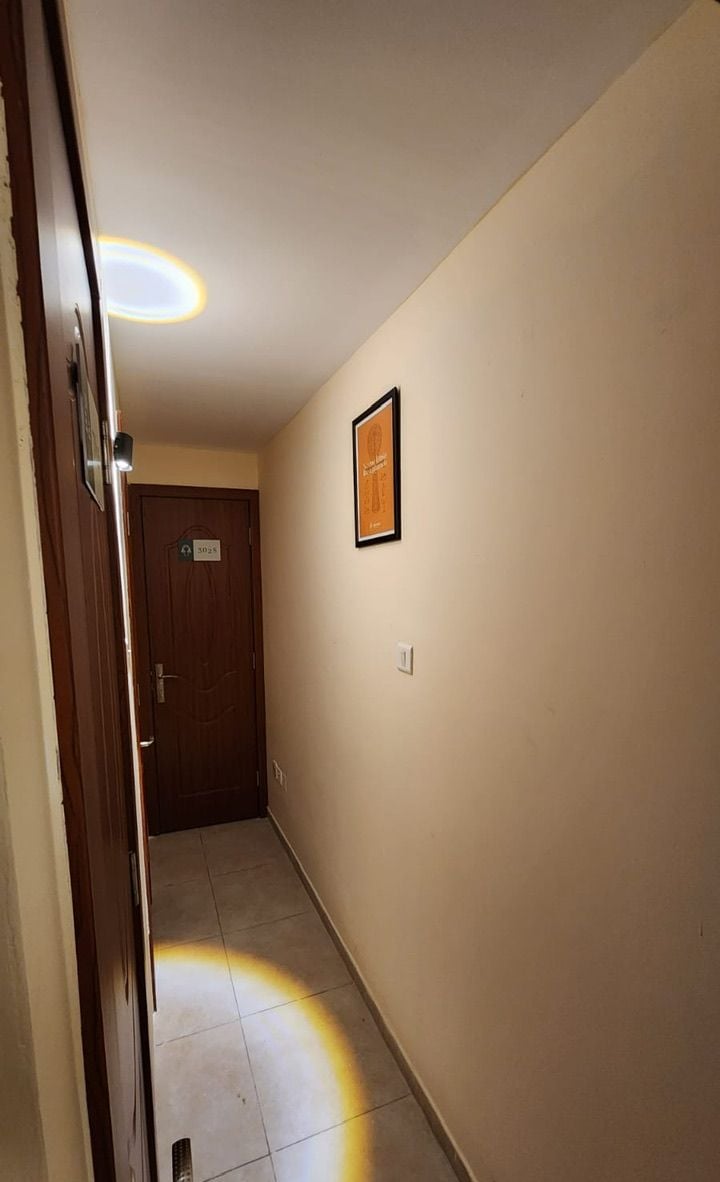 A hallway with a door labeled "302" and a framed picture on the wall.