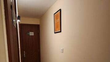 A hallway with a door labeled "302" and a framed picture on the wall.