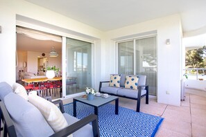Una sala moderna con un sofá, una mesa de centro y un comedor con sillas y una mesa.