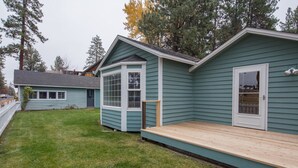 A two-story house with a deck, a front porch, and a small attached garage. - Pine Street Cottage 3 BDRM home in a great location, near downtown Sisters (Sisters)