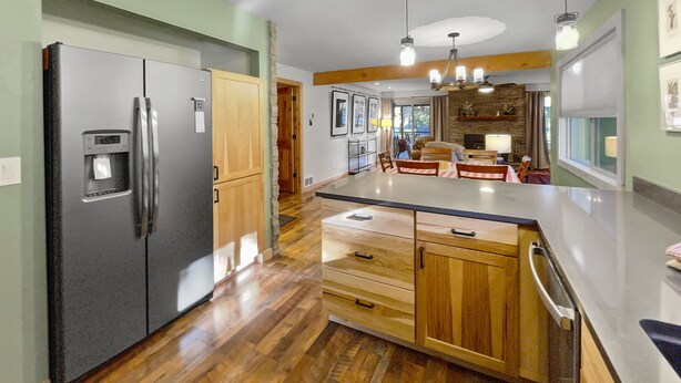A modern kitchen with a large island, stainless steel appliances, wooden cabinets, and pendant lighting. - Walk to Sisters | Hot Tub, Pool + Fireplace (Sisters)