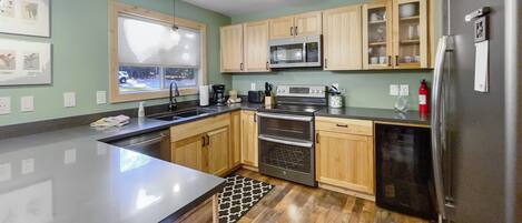 A modern kitchen with wooden cabinets, stainless steel appliances, and a large island.