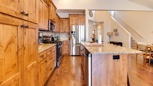 A kitchen with wooden cabinets, stainless steel appliances, and a large island. - The Quails Nest - charming 3 bedroom 2.5 bath with fireplace in Sisters Oregon (Sisters)