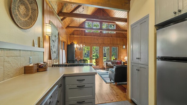 A kitchen with a built-in refrigerator, wooden cabinets, and a stone backsplash.