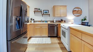Una cocina moderna con electrodomésticos de acero inoxidable, armarios de madera y una isla central.