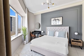 A modern bedroom with a large bed, a desk, and a view of the city. - Silkhaus 21st Century, DIFC Dubai (Dubai)